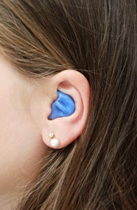 oreja de mujer con un tapón en el oído